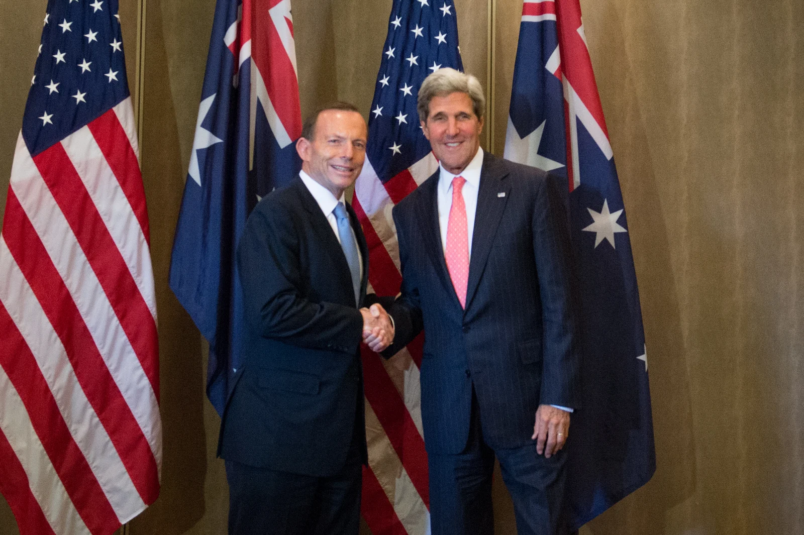 Tony Abbott, left in a pale-blue tie, shaking hands with John Kerry before Australian and United States flags in Bali in October 2013.