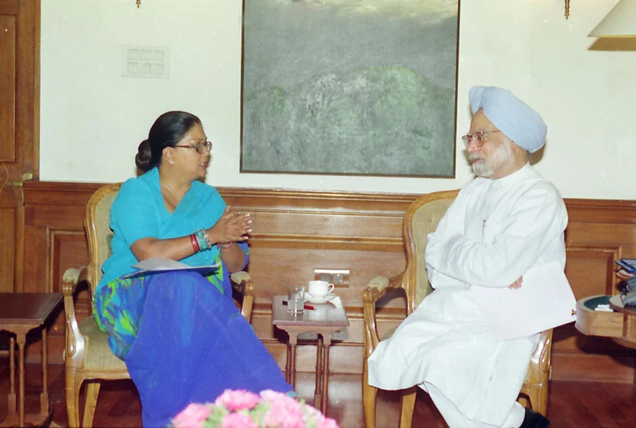 Vasundhara Raje sits at left talking with Prime Minister Manmohan Singh at right in a complete New Delhi meeting photograph from June 2004.