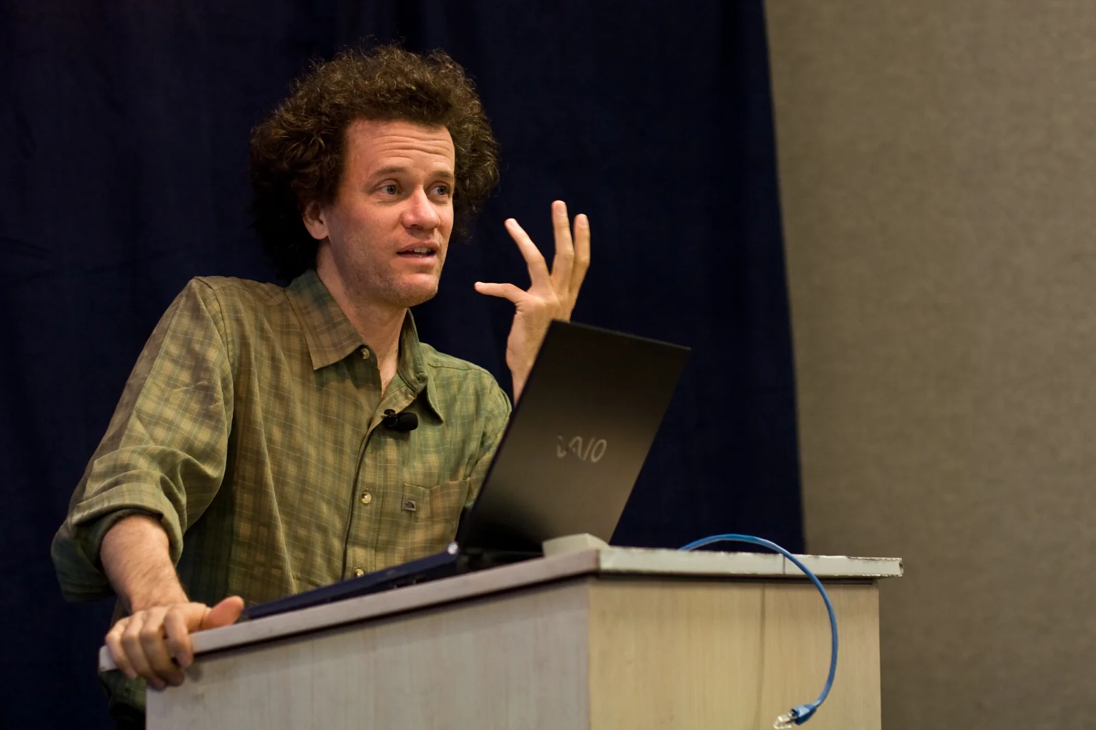 Yann Martel speaking behind a lectern and laptop during a Life of Pi presentation in Seattle in October 2007